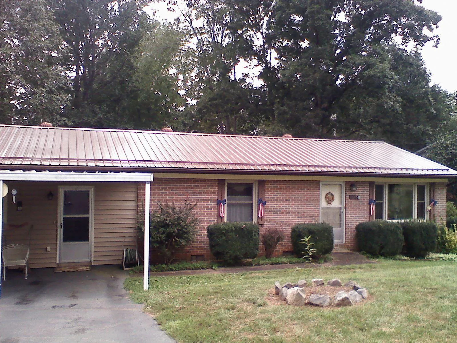 Bronze metal roof and carport on a brick ranch home — Roof Repair work by our crew in New Hudson