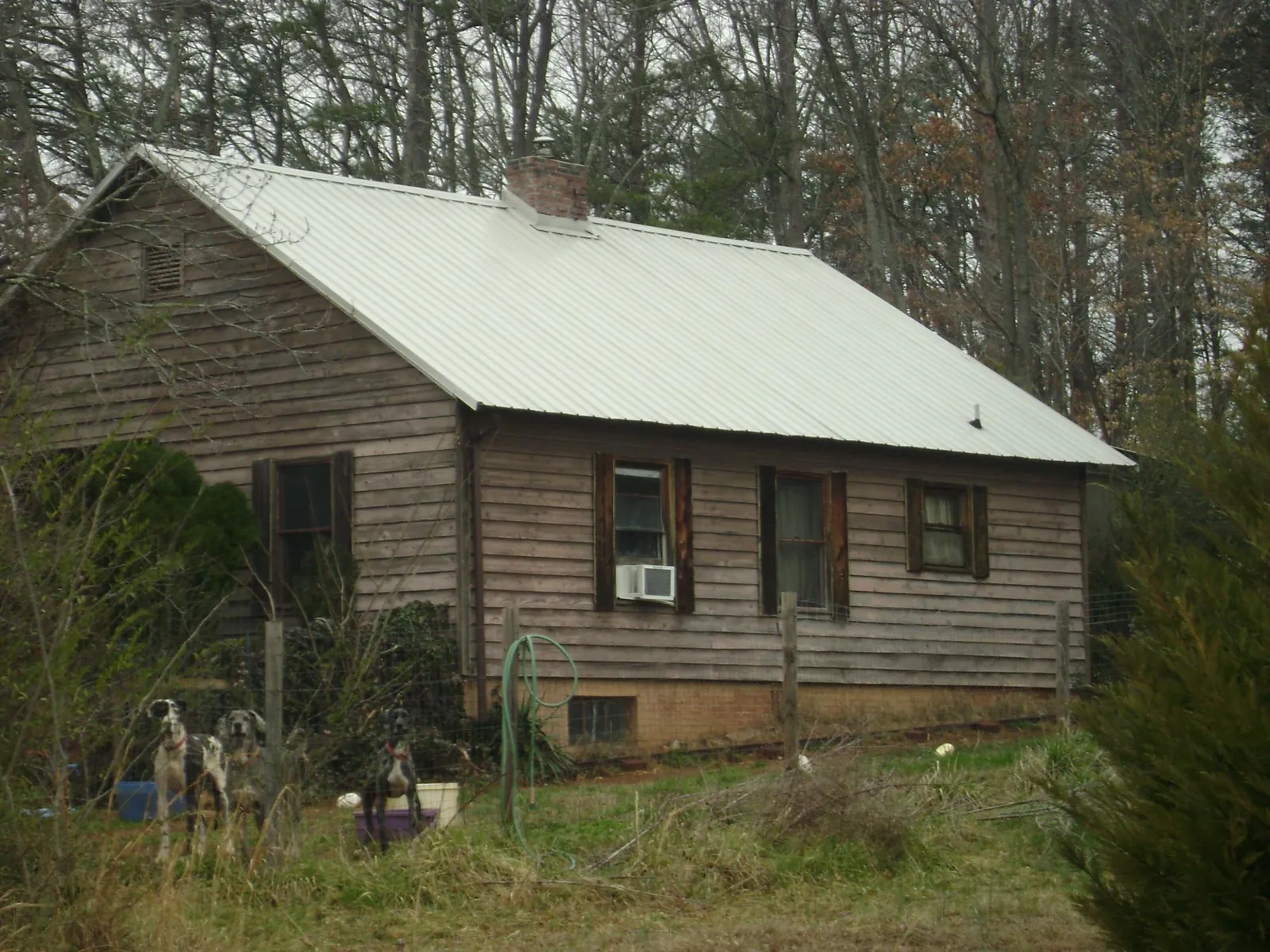 White metal roof on an old wood sided farmhouse, from a Metal Roof Installation job in New Hudson